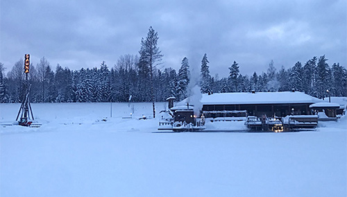 Tykkimäen saunarakennus talvisessa maisemassa. 