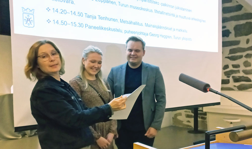 Tiia ja Santeri Kaartovuori-Knaapinen vastaanottivat kulttuuriympäristötekopalkinnon kulttuuriympäristötyöryhmän puheenjohtajalta Paula Saarennolta Turun linnassa pidetyssä seminaarissa. Kuva: Kirsti Virkki  Tiia ja Santeri Kaartovuori-Knaapinen tekivät merkittävän kulttuuriympäristöteon toteuttaessaan Björkön Södergrannasin kantatilan korjauksen. Kohde sijaitsee Paraisilla Korppoon Björkön saaressa ja on yksi saaren vanhoista kantataloista. Kulttuurihistoriallisesti arvokas kohde oli päässyt huonoon kuntoon oltuaan pitkään tyhjillään ja sai uuden elämän ansiokkaasti toteutetun korjauksen yhteydessä. Vanhaan päärakennukseen sijoitetun kesäkahvilan myötä Björkö on avautunut myös asiakkaille ja lisännyt saaren kulttuuriympäristön vetovoimaisuutta. Kulttuuriympäristötyöryhmä toivottaa Södergrannasin kantatilalle elinvoimaista tulevaisuutta. Kulttuuriympäristöteko -palkinnon tarkoituksena on rohkaista ja innostaa  Nyt neljättä kertaa jaettavan Varsinais-Suomen kulttuuriympäristöteko -palkinnon tarkoituksena on rohkaista ja innostaa alueen kuntia, yhteisöjä ja yksityisiä kansalaisia vaalimaan omaa kulttuuriympäristöään. Palkinto voidaan myöntää laaja-alaiselle kulttuuriympäristön hyväksi tehtävälle työlle tai yksittäisen rakennuksen kulttuurihistorialliset arvot säilyttävälle kunnostustyölle. Olennaista on, että teko voi toimia mallina ja esimerkkinä muille. Vuonna 2023 palkinto annettiin Uudenkaupungin arkkitehtuuripoliittiselle ohjelmalle. Kulttuuriympäristöteko -palkinnon jakaa Varsinais-Suomen kulttuuriympäristötyöryhmä   Runsaat 20 vuotta toimineen työryhmän on nimennyt Varsinais-Suomen ELY-keskus ja vastaava alueellinen ryhmä toimii Suomen kaikissa maakunnissa. Siinä ovat edustettuina Varsinais-Suomen ELY-keskuksen ohella Varsinais-Suomen liitto, Varsinais-Suomen alueellinen vastuumuseo, Museovirasto, Metsähallitus, ProAgria Länsi-Suomi / Maa- ja kotitalousnaiset, Finska Hushållningssällskapet, Senaatti-kiinteistöt, Bryggman-instituutti, Valonia, Turun kaupunki, Naantalin kaupunki, Salon kaupunki, Paraisten kaupunki, Uudenkaupungin kaupunki, Loimaan kaupunki, Kemiönsaaren kunta, Kosken Tl kunta, Marttilan kunta ja Oripään kunta. Ryhmän tehtävänä on edistää ja ohjata maakunnassa tehtävää kulttuuriympäristötyötä sekä lisätä yhteistyötä ja tiedonkulkua toimijoiden kesken.   Lisätietoja:  Ylitarkastaja Kirsti Virkki, Varsinais-Suomen ELY-keskus p.0295 022 525, etunimi.sukunimi@ely-keskus.fi  Intendentti Paula Saarento, Varsinais-Suomen alueellinen vastuumuseo, p. 040 7075 104, etunimi@sukunimi@turku.fi