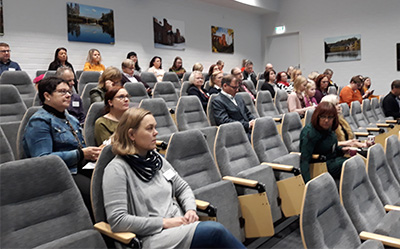 Kuva auditoriossa istuvista ihmisistä. 