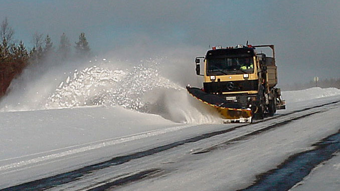 Aura-auto liikkeellä ja lumi pöllyää. 