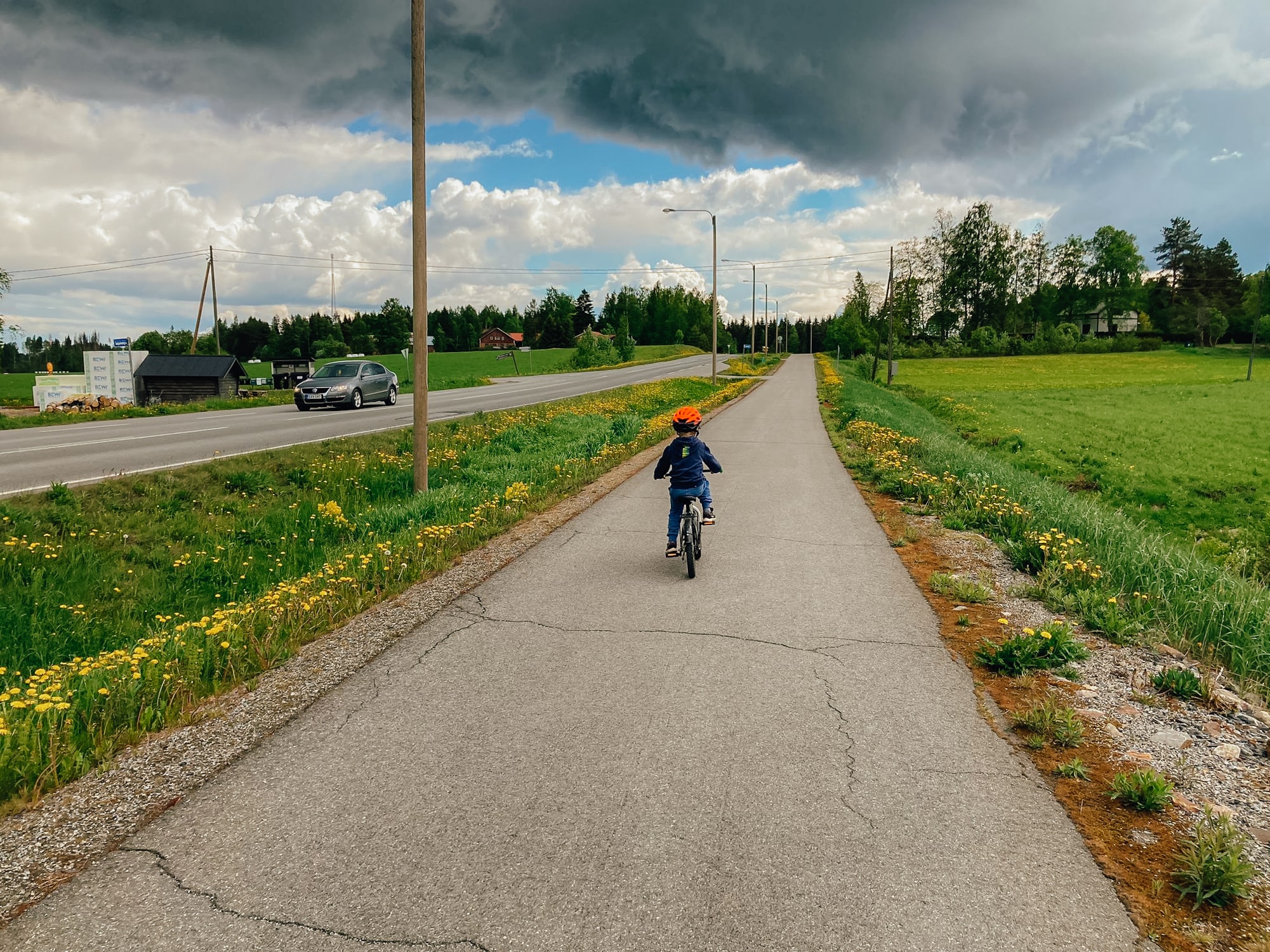 Lapsi pyöräilemässä pyöräilyväylällä kesäisenä päivänä.
