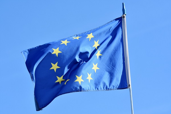 EU-lippu liehuu sinistä taivasta vasten.