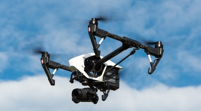 Drone lentää sinisellä taivaalla.