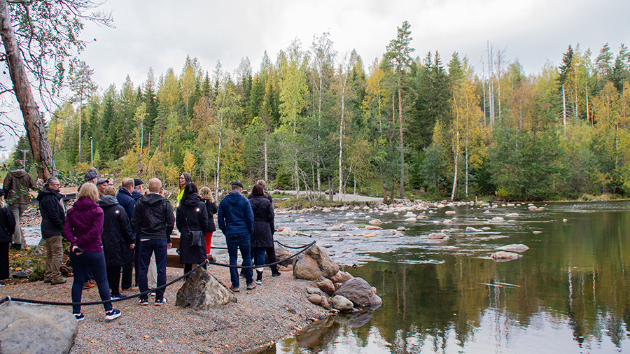 Ihmisjoukko seisoo joen vierellä.