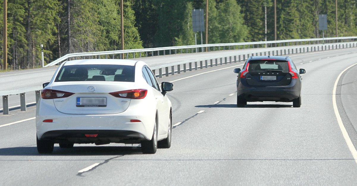 Kaksi henkilöautoa keskikaidetiellä.