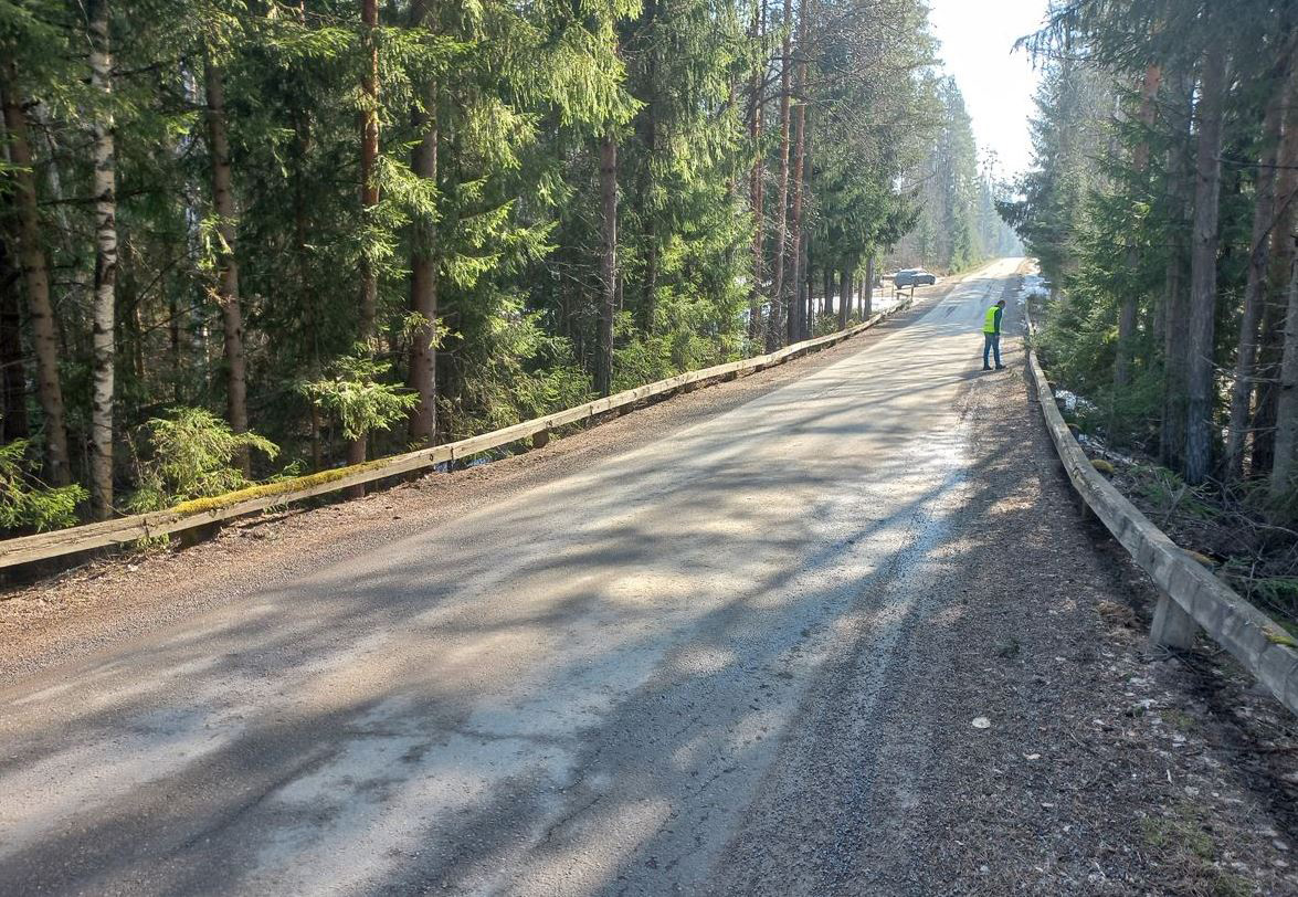 Mies seisomassa soratiellä, ympärillä metsää. 