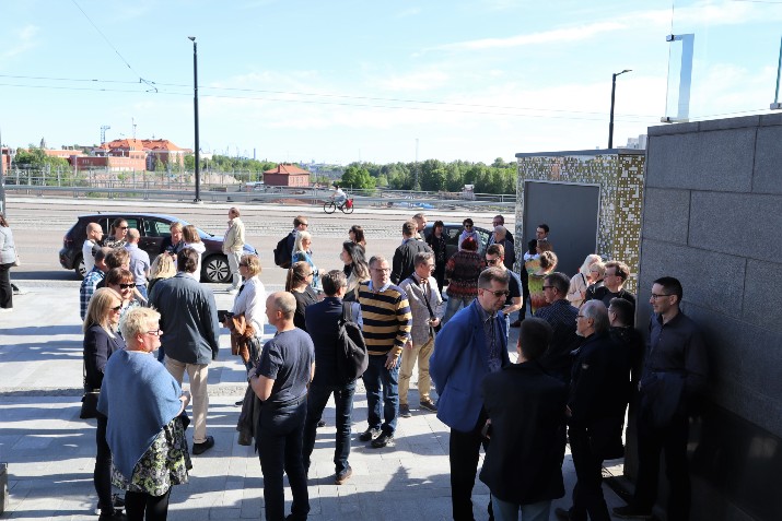 Kuvassa osallistujat seisovat ulkona juttelemassa.