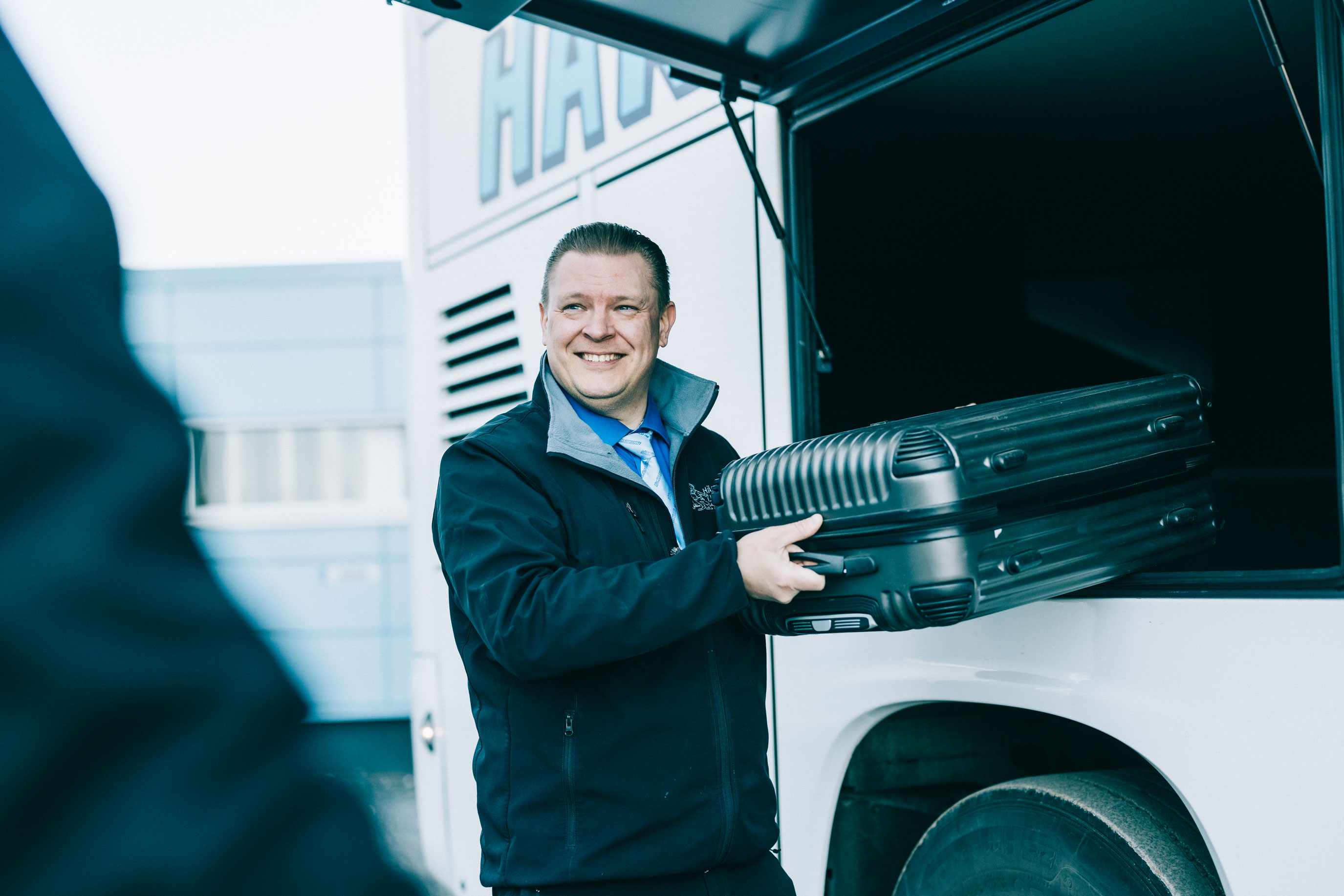 Kuljettaja laittaa laukkua Härmän Liikenteen bussin tavaransäilytystilaan.