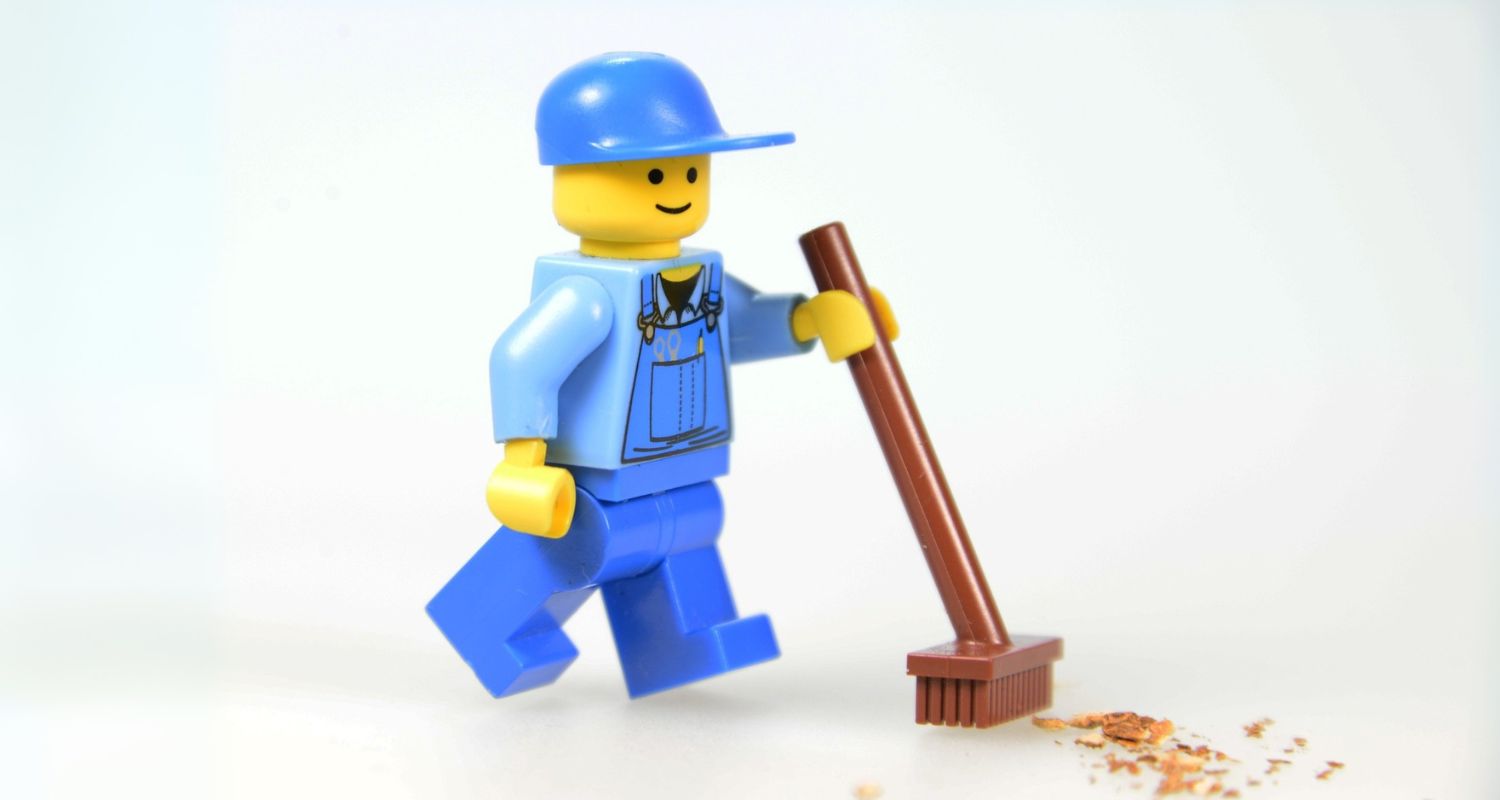 Kuvassa on legohahmo, jolla on katuharja kädessään.