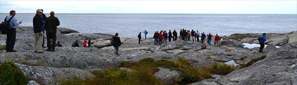 Ryhmä retkeilijöitä rantakallioilla.