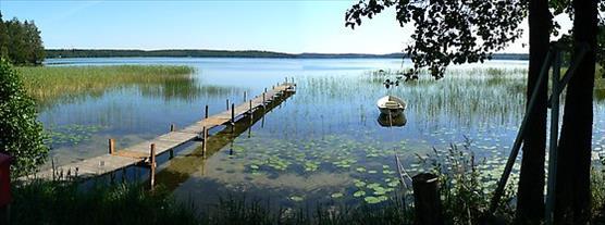 Kesäinen rantamaisema, jossa pitkä laituri.