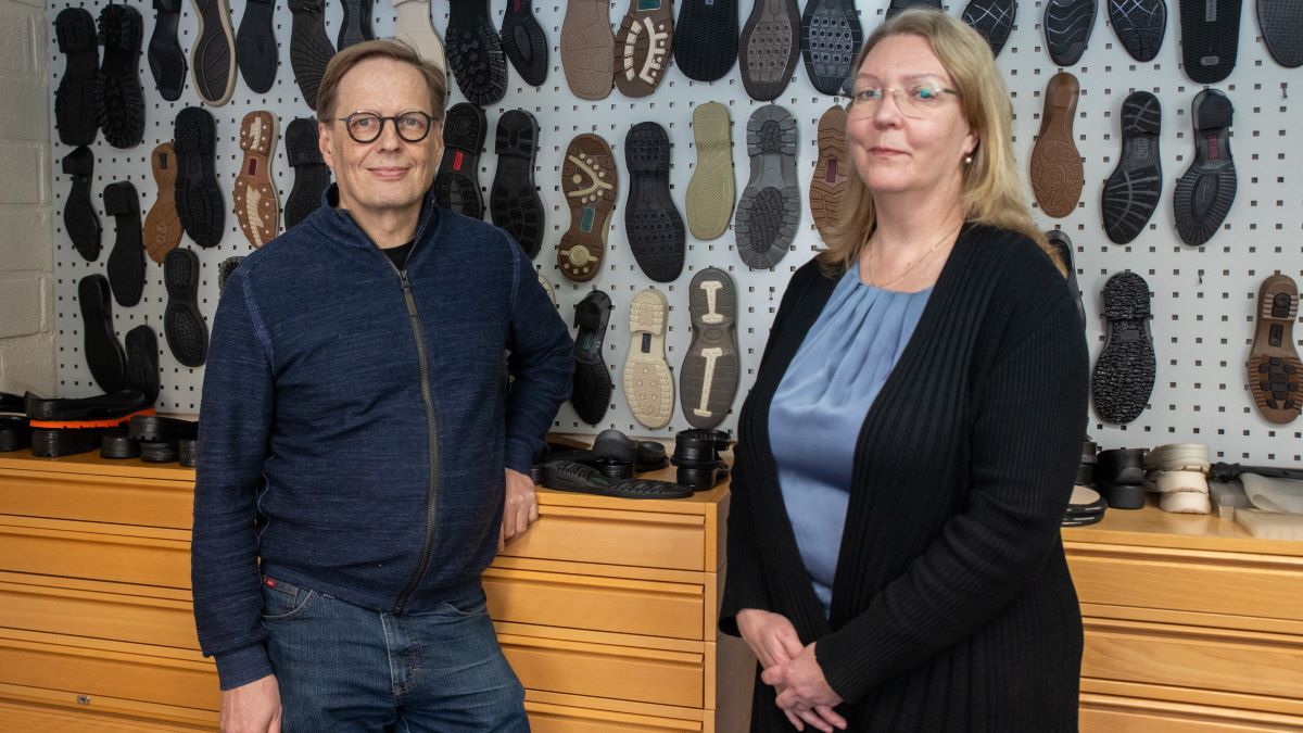 Juha Alitalo ja Annamaija Mäkilouko Lenkki Oyn toimistolla. Taustaseinällä yrityksen tuotteita kuten erilaisia kengänpohjia esillä.