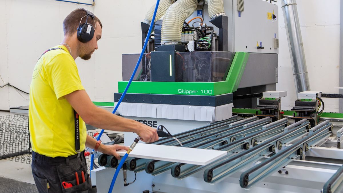 Mies käyttää CNC-konetta Porin Puukalusteen tiloissa.