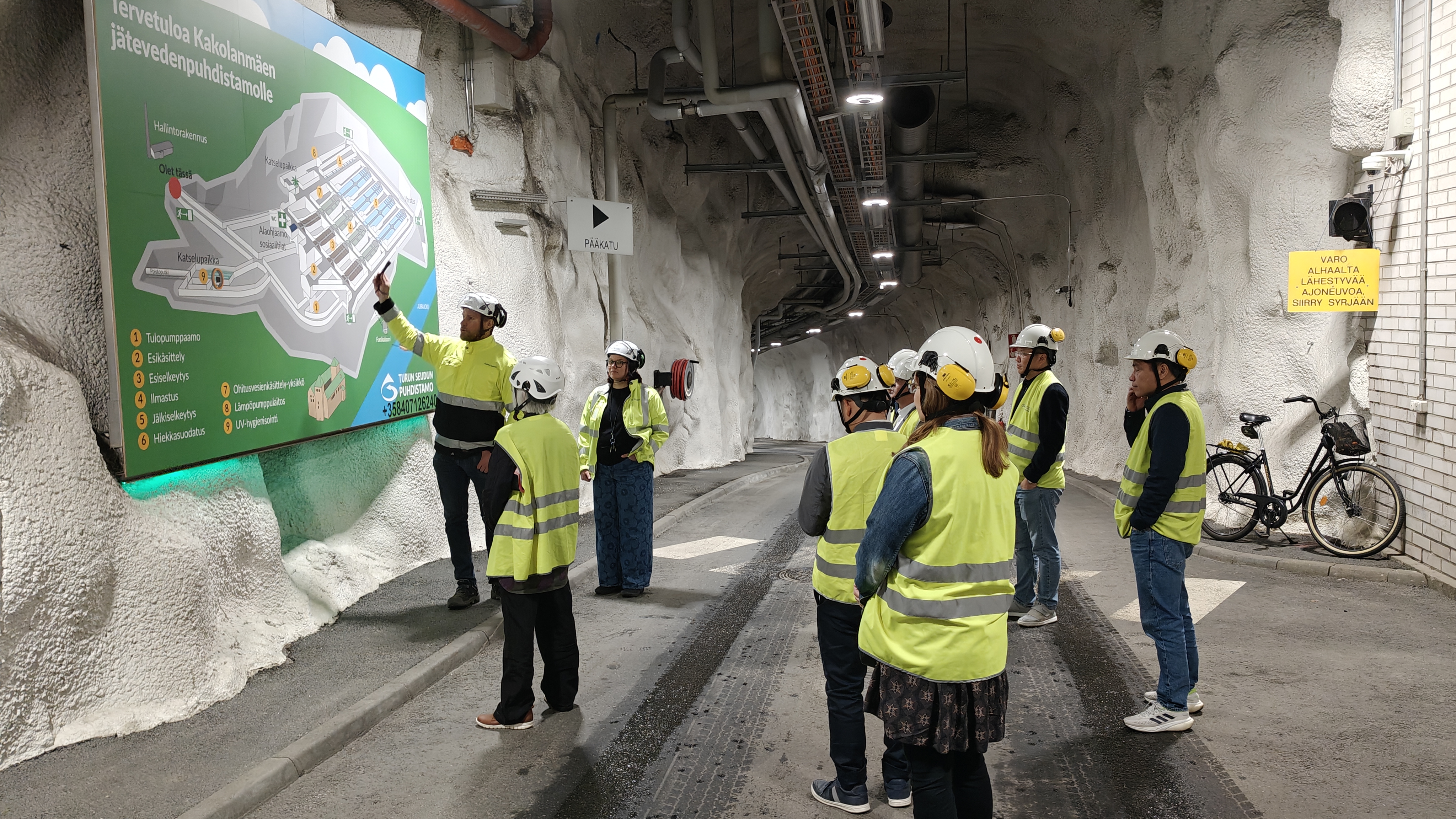 Ihmisiä turvavarusteissa tunnelissa.