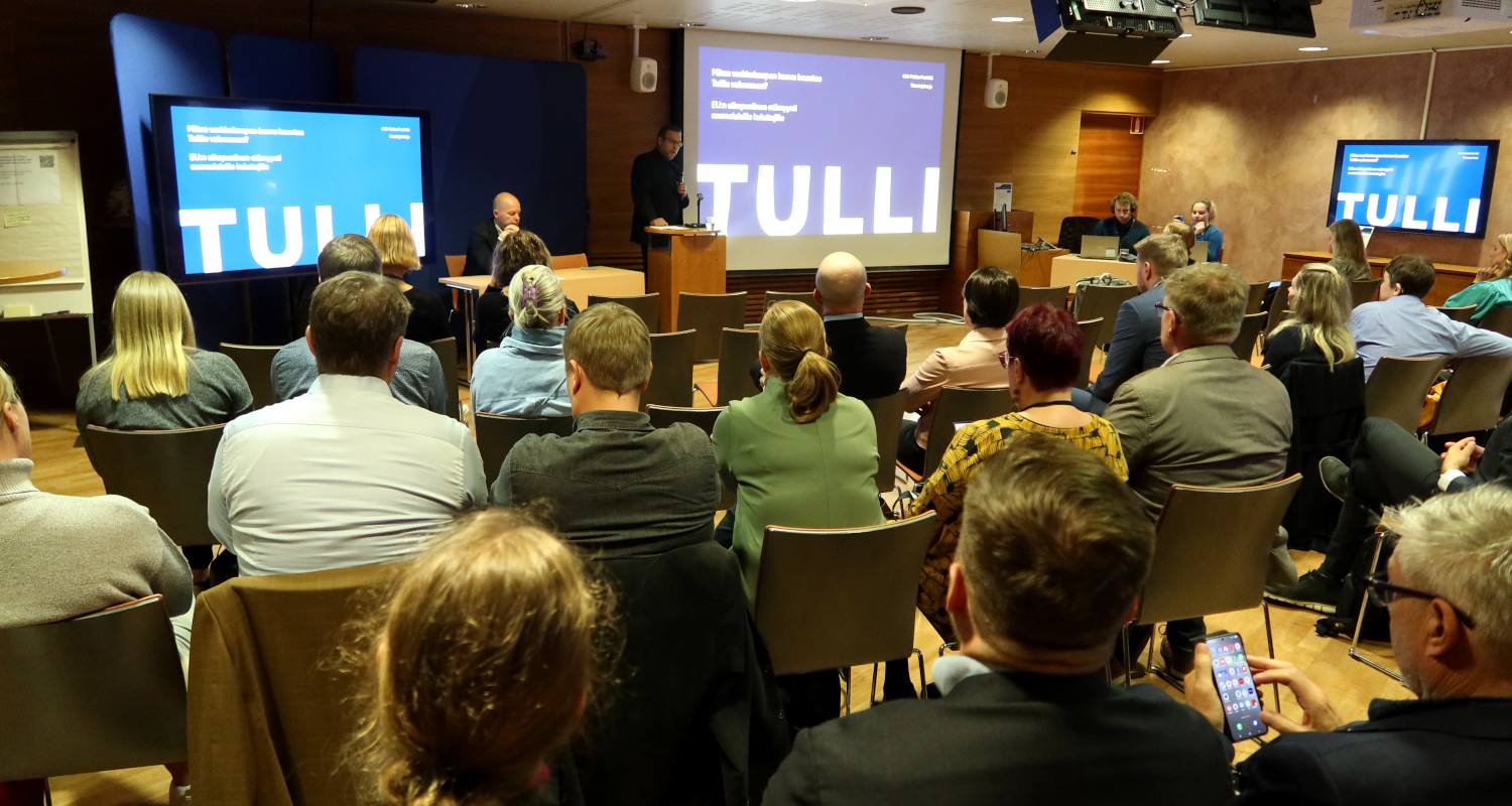 Kuvassa on seminaariyleisöä ja puhujia.